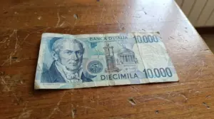 Banconota da 10.000 lire con Alessandro Volta appoggiata su un tavolo di legno, usurata e con pieghe visibili