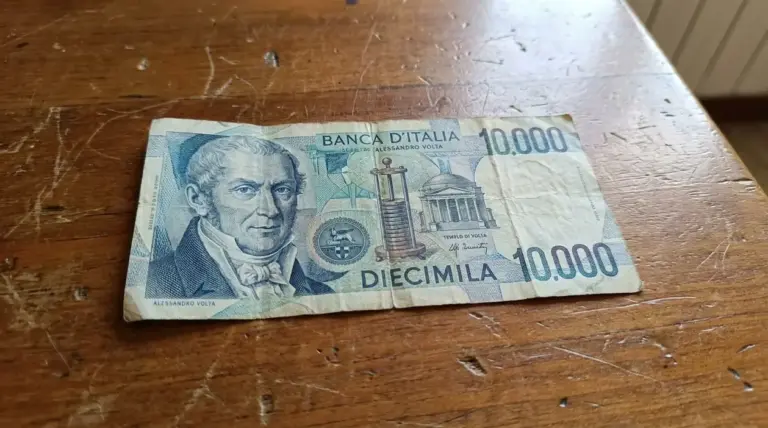 Banconota da 10.000 lire con Alessandro Volta appoggiata su un tavolo di legno, usurata e con pieghe visibili