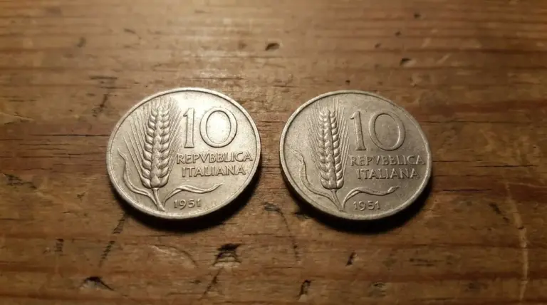 Confronto tra due monete da 10 lire del 1951 con spiga di grano, affiancate su un tavolo di legno