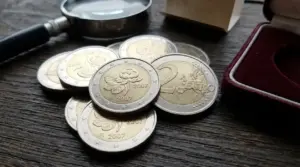 Monete da 2 euro Finlandia 2007 commemorative su tavolo in legno, con lente d’ingrandimento e astuccio