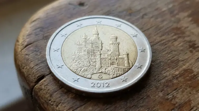 Moneta da 2 euro Germania 2012 con castello e lettera G della zecca, in primo piano su superficie di legno