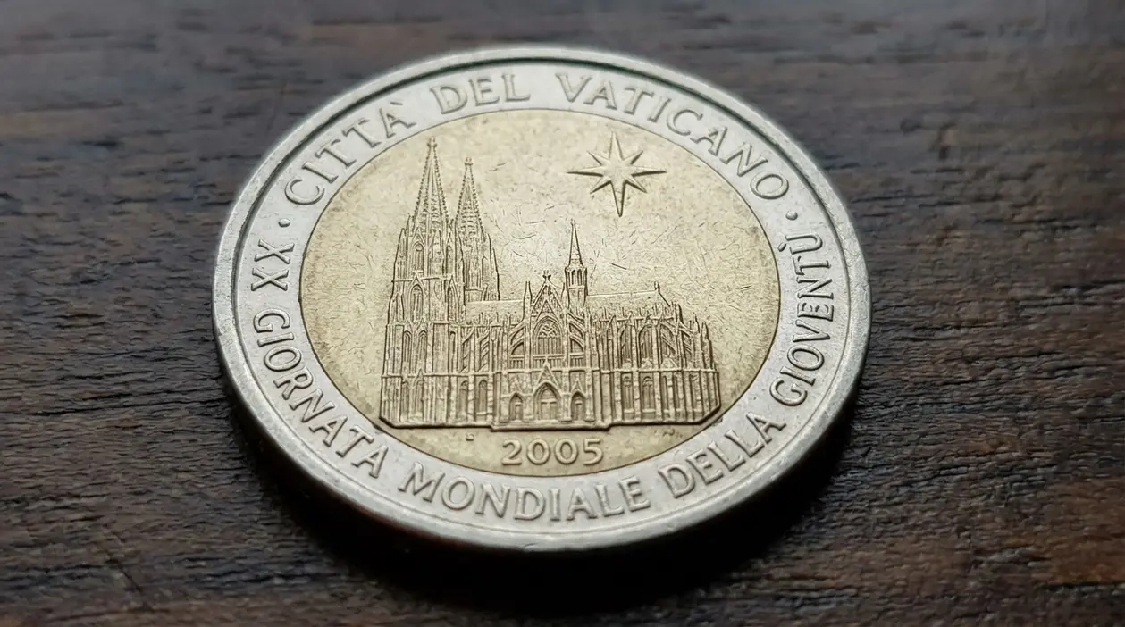 Moneta da 2 euro del Vaticano 2005 con basilica incisa, fotografata su superficie in legno