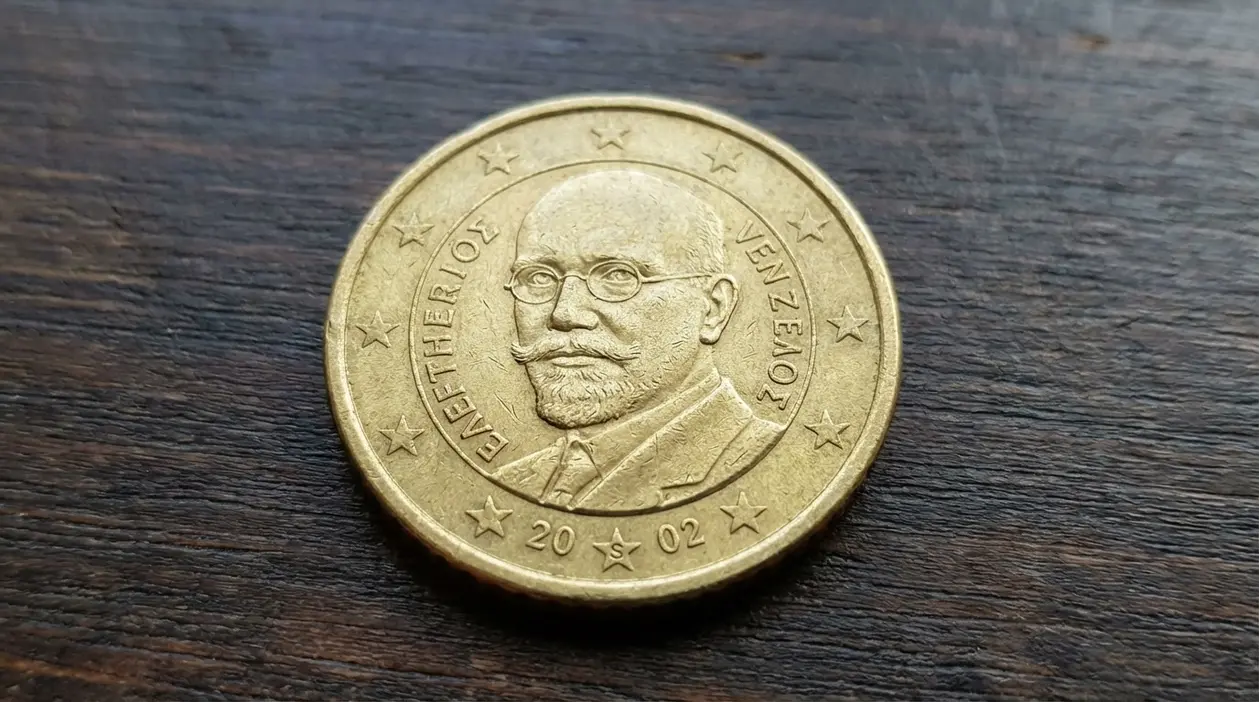 Moneta da 50 centesimi euro della Grecia 2002 con ritratto su sfondo in legno, dettaglio del dritto