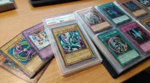 Carte Yu-Gi-Oh! da collezione in raccoglitore, con una carta rara in custodia rigida su un tavolo