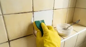 Rimedio fai da te per sbiancare le piastrelle del bagno con una spugna e una miscela cremosa