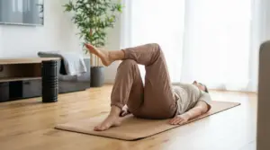 Persona sdraiata su un tappetino esegue un esercizio per le gambe in un ambiente domestico luminoso