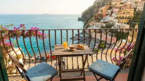 Colazione su un balcone con vista sul mare e case colorate in Costiera Amalfitana