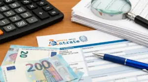 Documenti fiscali con banconote in euro, calcolatrice, penna e lente d’ingrandimento su scrivania