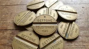 Gettoni telefonici italiani del 1969 disposti su una superficie in legno