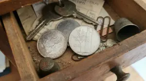 Monete italiane in lire in un cassetto di legno con chiavi e piccoli oggetti, possibile moneta rara da collezione