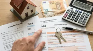 Documenti IMU e cedolare secca con calcolatrice, contanti, chiavi e modellino di casa su un tavolo